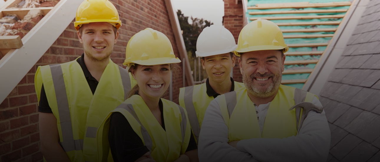 A group of four construction workers of different ages