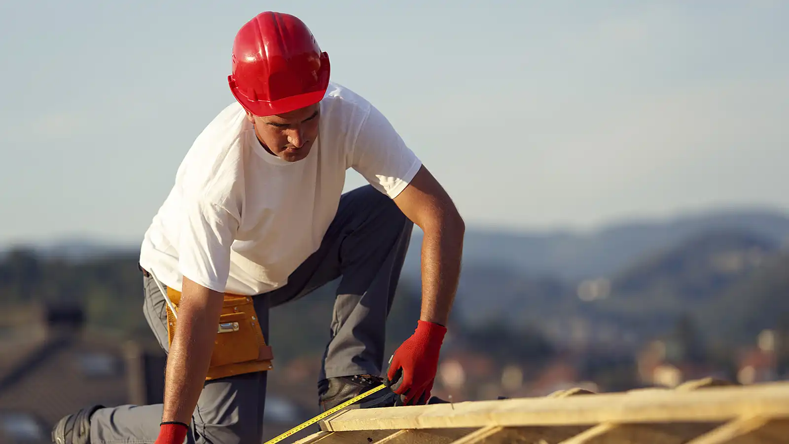 A builder on the roof of a construction site