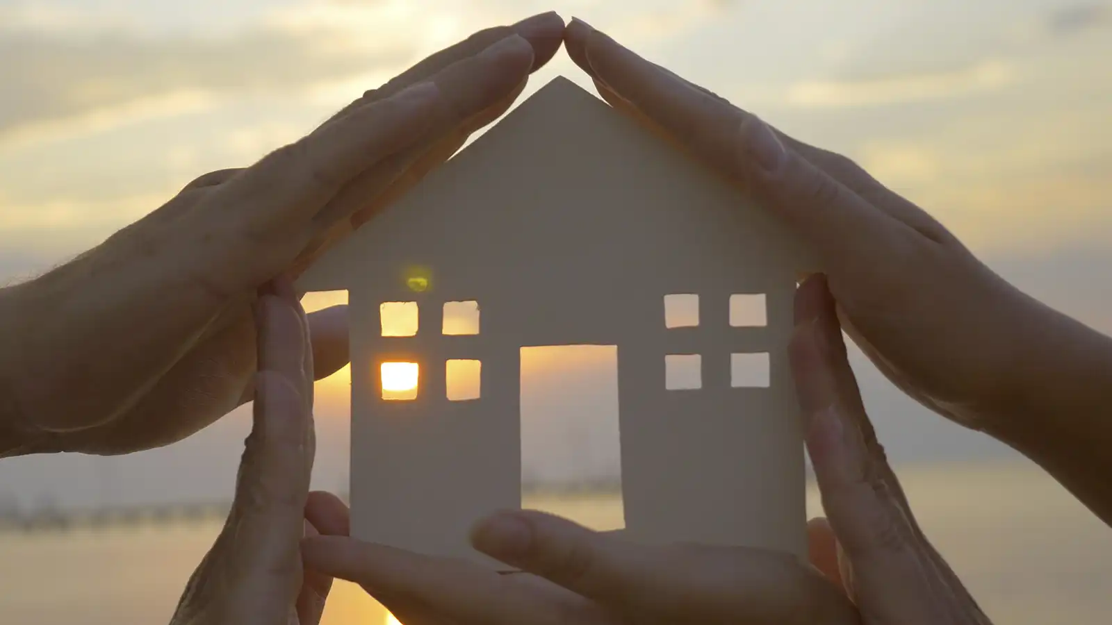 A concept image of hands holding a house